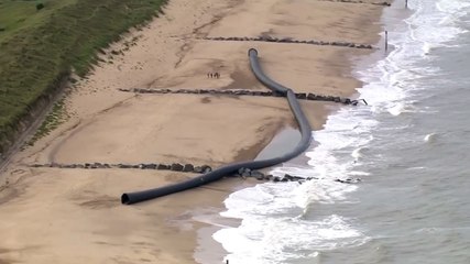 De gigantesques tuyaux s'échouent sur une plage et intriguent les promeneurs