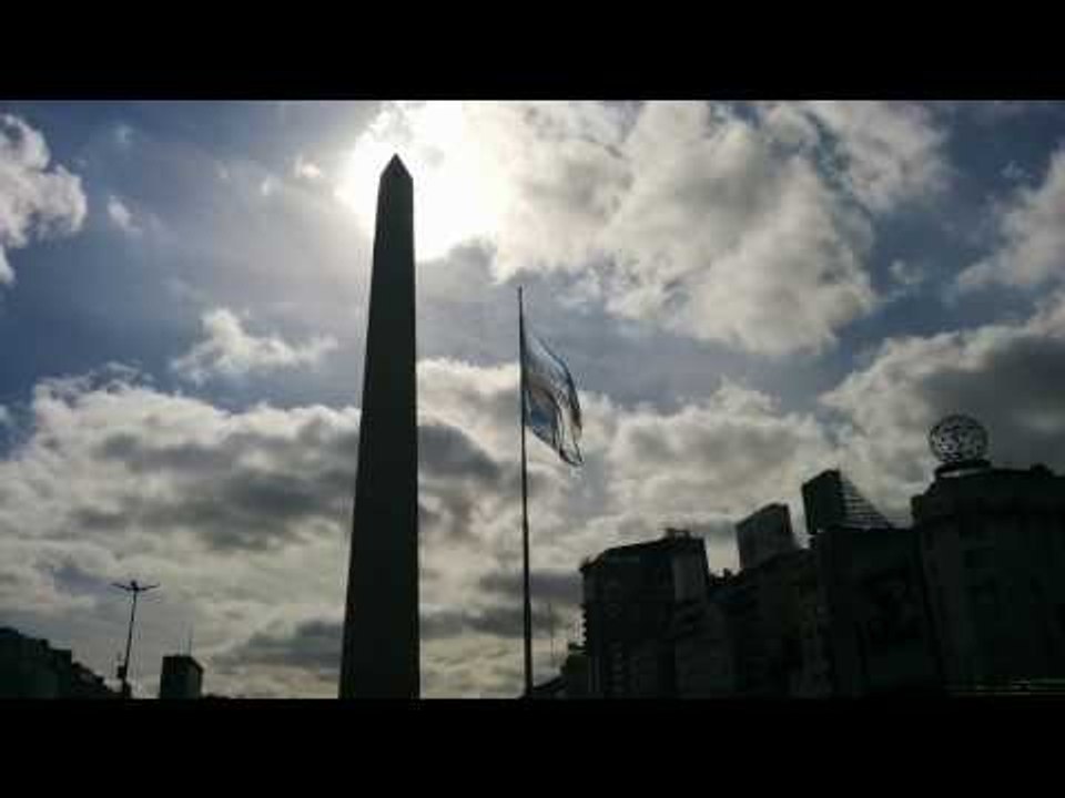 Obelisco de Buenos Aires con la Bandera Argentina flameando.