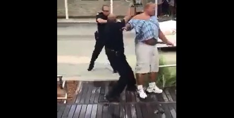 Plusieurs policiers tente de maîtriser un homme.