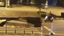 Motorist using his mobile phone drives scooter into massive sinkhole