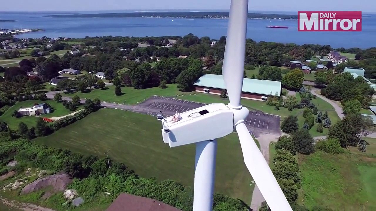 Un homme surpris par un drone en pleine séance de bronzage au sommet d'une éolienne.