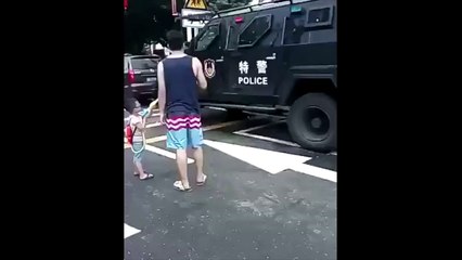 Скачать видео: Un enfant joue avec un policer caché dans un blindé au pistolet à eau !