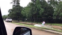 Man wakeboards in flooded ditch after Hurricane Harvey