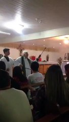 Il bénit ses fidèles avec un pulvérisateur