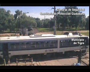 Un homme pousse une voiture sur un passage à niveau