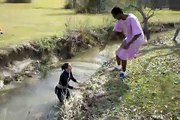 Une fille saute par-dessus un ruisseau