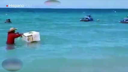 A este heladero no le importa meterse al mar con tal de vender