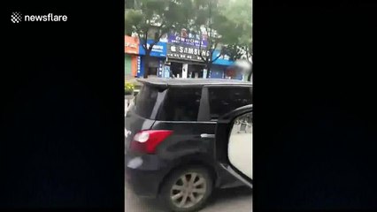Disgruntled woman sits on hood of husband's moving car