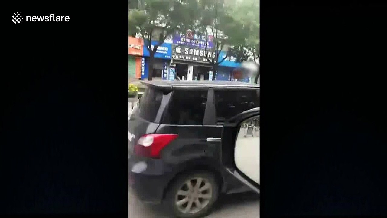 Disgruntled woman sits on hood of husband's moving car