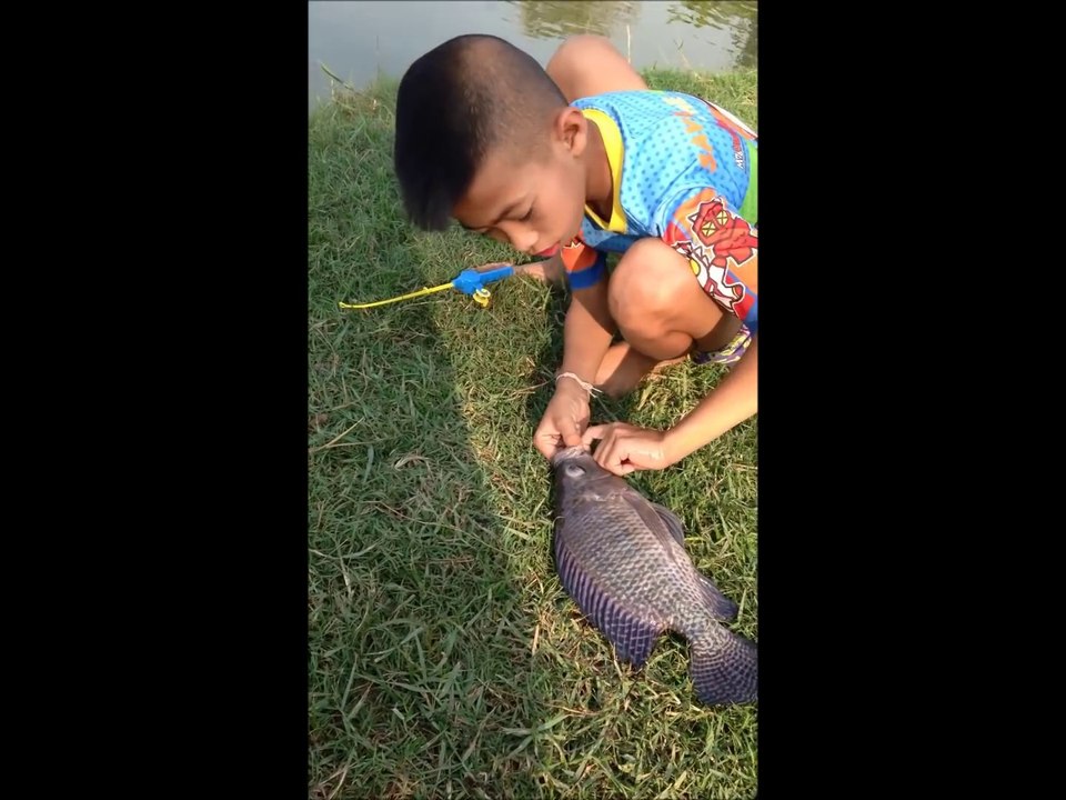 Ce gamin attrape un beau poisson avec son jouet canne à peche...