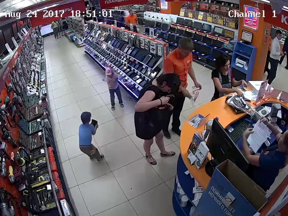 2 gamins volent un iPad relié à un cable de sécurité sous les yeux d'n vendeur