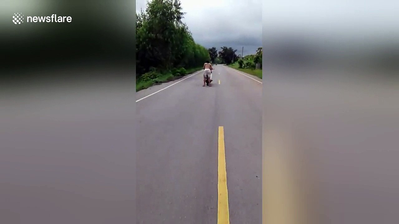 Daredevil motorcyclist skids along road in flip flops
