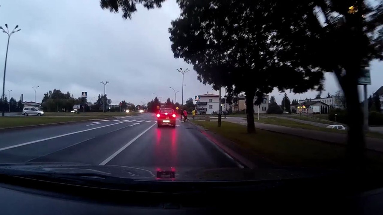 Deux voitures s'arrêtent pour laisser traverser des piétons..