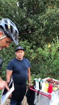 Un policier prend l'argent d'un vendeur de hot dog