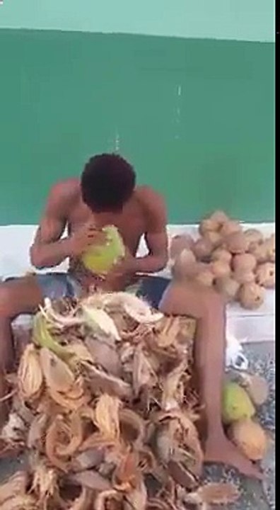 Indian man strong teeth peel coconut