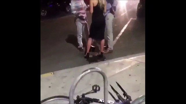 Une femme bourré se pisse dessus juste devant une boîte de nuit bondée