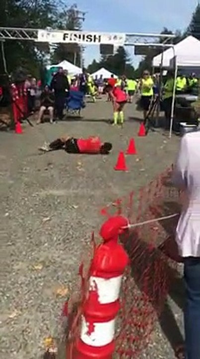 Une marathonienne terrassé par crampe doit rouler pour franchir la ligne d'arrivée