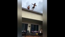 Un jeune homme tente de faire un salto à partir d'un toit.