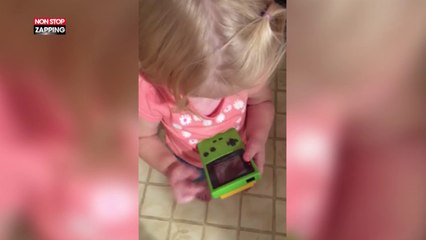 Elle essaie de jouer avec une Gameboy mais, trop jeune, elle ne sait pas comment marchent des boutons (Vidéo)