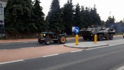 Un tracteur aide un blindé qui est en panne.