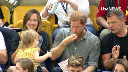 Prince Harry shares his popcorn with little girl