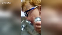 Boy struggles to drink from fountain