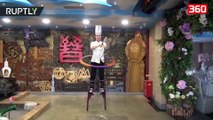 Kuzhinieri kinez kombinon gatimin dhe akrobacinë me “prerjen e kokës” (360video)