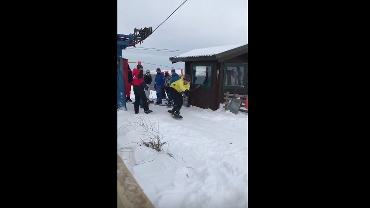 Des snowboardeurs débutants prennent le tire-fesses