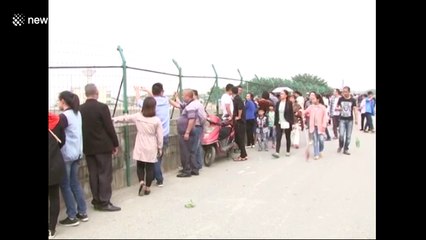 Chinese tourists watch tidal bore race up Qiantang River