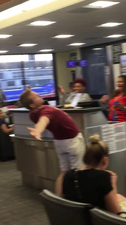 Un homme chante au micro devant une porte d'aéroport