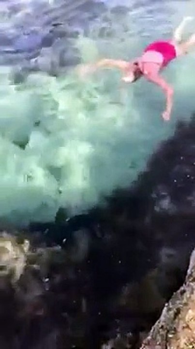 Une femme attrape un requin coincé dans une piscine océanique pour le remettre à la mer