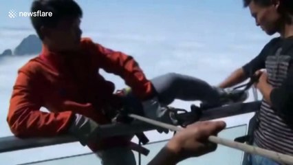 Cleaners abseil to pick up rubbish from cliff under glass bridge