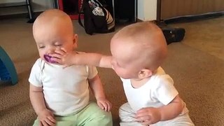 Twin baby girls fight over pacifier