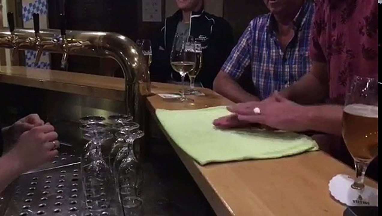 Un homme fait un petit tour de magie à la serveuse d’un bar