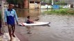 Alagamento obriga homem a sair de casa com bote, em Vila Velha