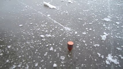 Il tire sur la glace au revolver et la balle tourne comme une toupie !