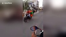 Passionate bull tries to mount motor scooter shocking its two riders
