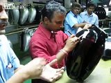Skilled craftsman hand painting pinstripes at Royal Enfield motorcycle factory in India