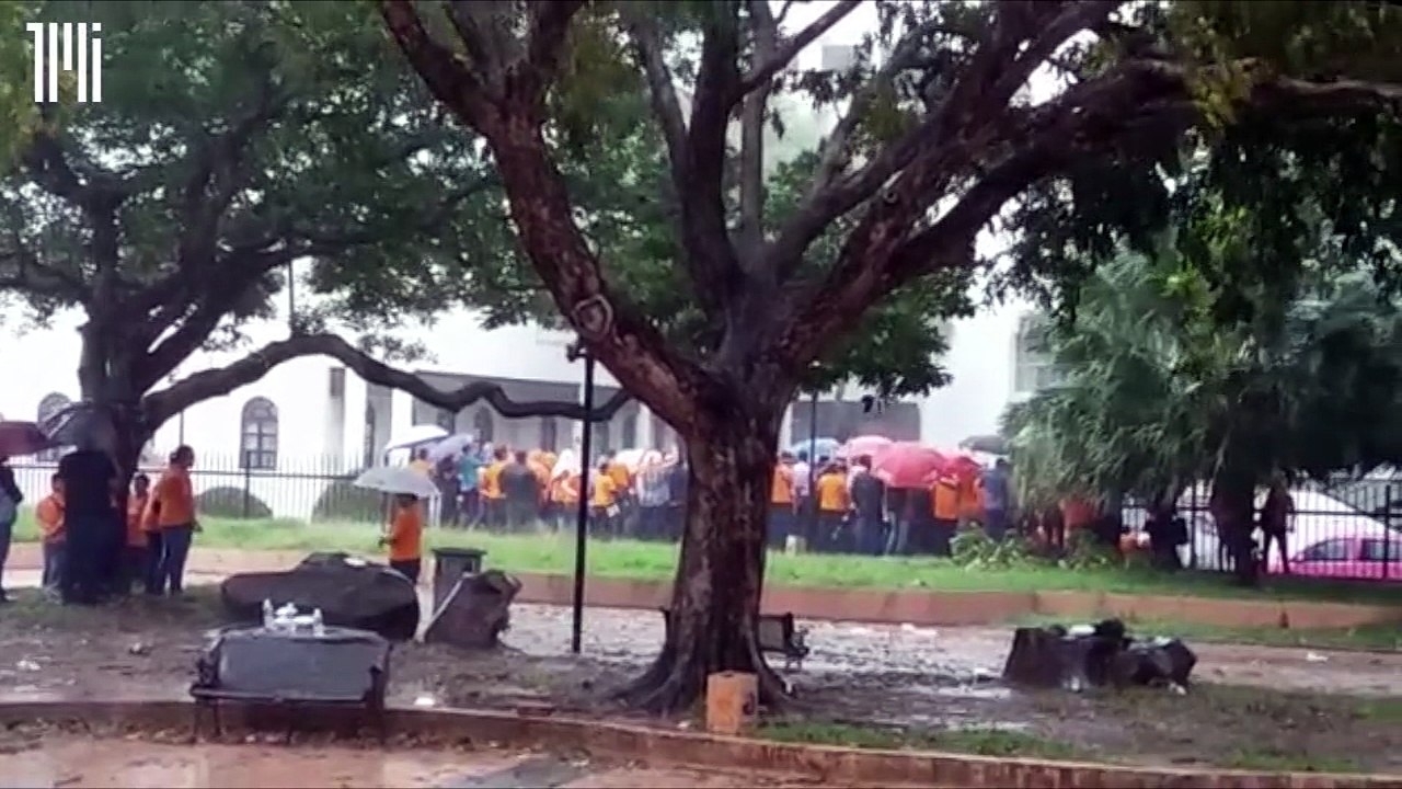 Supporters wait in the rain for Shafie to emerge from the ambulance.