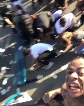 Ce rappeur balance une liasse de 2000$ dans une cours d'école et tout le monde devient fou