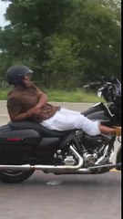 Un motard allongé sur sa Harley-Davidson