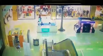 Une fillette emportée par la rampe d'un escalator