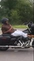 Un motard allongé sur sa Harley Davidson en pleine circulation