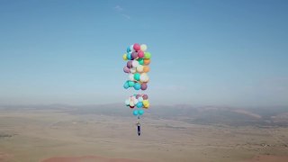 He flies through the air with balloons