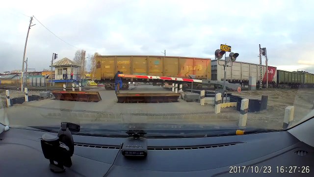 Un cycliste inconscient passe entre deux trains sur un passage à niveau