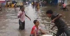 Children Play on Flooded Street as Heavy Rain Prompts School Closures in India