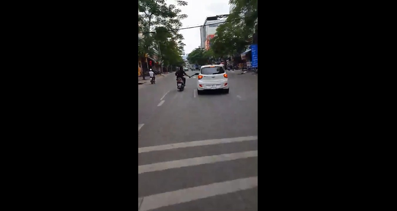Un scootériste pète un plomb et met des coups de machettes sur les rétroviseurs des voitures.