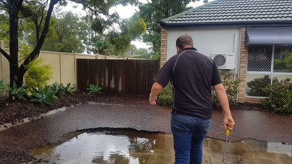 Plumber clearing a blocked grate after storm