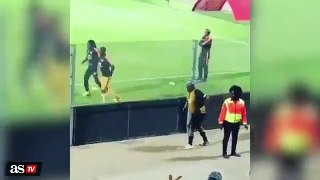 A funny soccer fan warming up alongside his favorite player