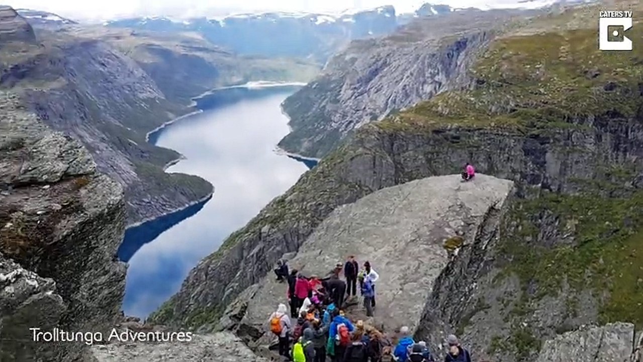 Des randonneurs font la queue pour une photo sur un rocher